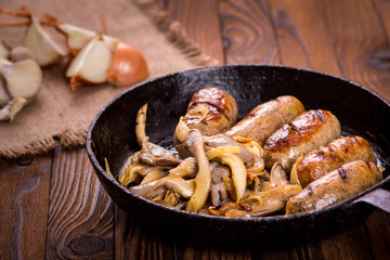 sausage and mushrooms in a frying pan