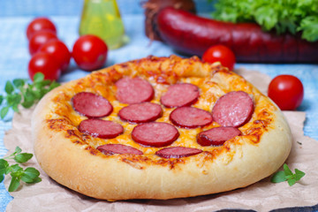 Hot Homemade Pepperoni Pizza on a wooden background with vegetables Ready to Eat