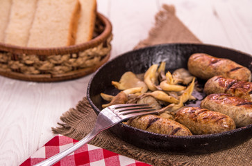 sausage and mushrooms in a frying pan