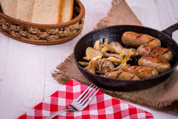 sausage and mushrooms in a frying pan