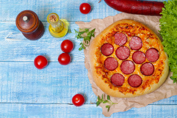 Hot Homemade Pepperoni Pizza on a wooden background with vegetables Ready to Eat