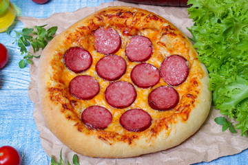 Hot Homemade Pepperoni Pizza on a wooden background with vegetables Ready to Eat