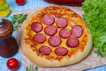 Hot Homemade Pepperoni Pizza on a wooden background with vegetables Ready to Eat