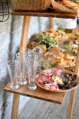 Antipasto catering platter with bacon, jerky, sausage, blue cheese and grapes on a wooden background