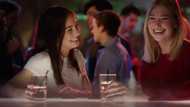 girl meets her friend at bar in club and is beeing introduced