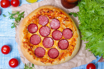 Hot Homemade Pepperoni Pizza on a wooden background with vegetables Ready to Eat