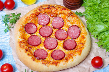 Hot Homemade Pepperoni Pizza on a wooden background with vegetables Ready to Eat