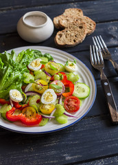 Fresh salad with cherry tomatoes, cucumbers, sweet peppers, celery and quail eggs. Healthy tasty food