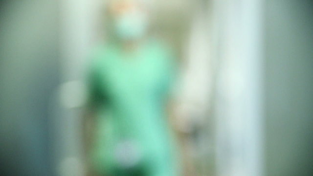 Medical personal walking in the hall of hospital, unfocused background