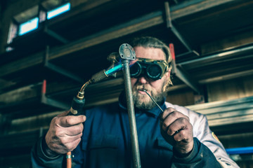 Man with goggles soldering iron pipe