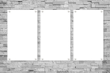 three white poster on grey stone wall
