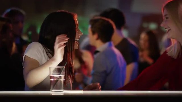 Two girls meet up in bar