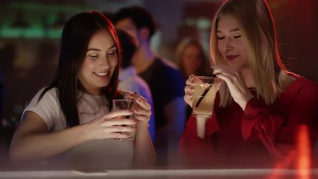 two girls clinking glasses