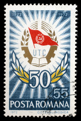 Stamp printed in Romania shows Badge and laurel wreath, 50 Years Communist Youth League, circa 1972.