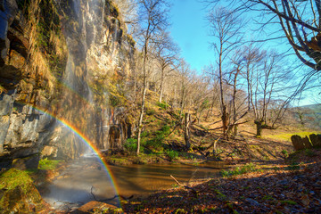 Rainbow waterfall in the winter forest