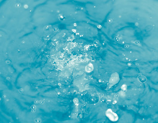 Naklejka na ściany i meble Drops of water falling into blue water