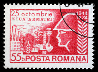 Stamp printed in Romania shows Army Day, soldier before industrial complex, circa 1974.