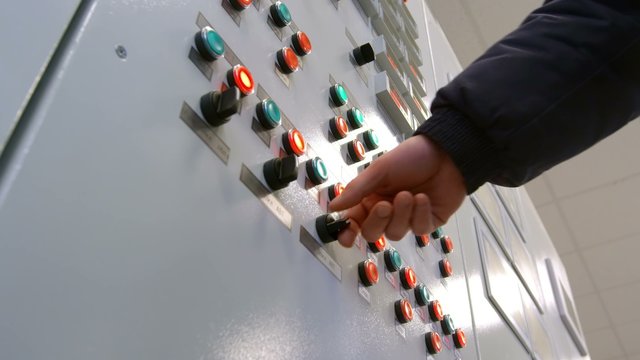 engineer presses the button on modern control panel