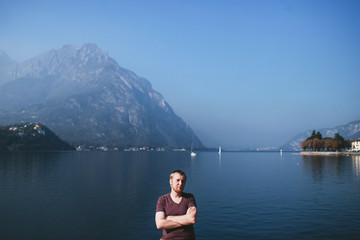 Fototapeta na wymiar bearded man on the background of a mountain lake Como