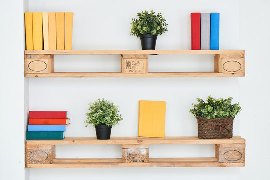 Books and flowers on wooden shelf