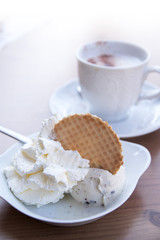 vanilla ice cream ball with whipped cream and biscuit in a bowl
