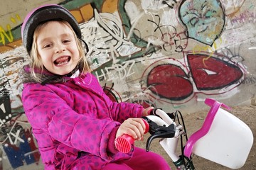 petite fille souriante à vélo