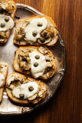 Crostini with fried mushrooms, onion and mozzarella cheese