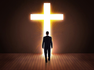 Man looking at bright cross sign