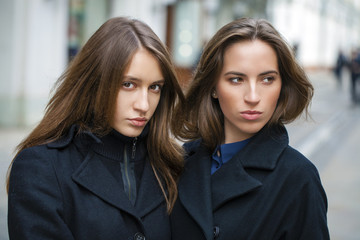 Close Up portrait of two friends in a black coat