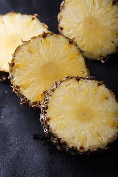 Pineapple ,fresh and ripe sliced on a dark background.A tropical fruit.