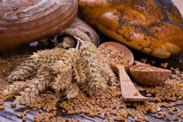 Assortment of baked bread on wooden table background