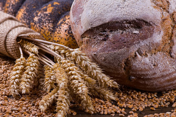 Assortment of baked bread on wooden table background