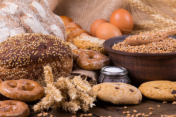 Assortment of baked bread on wooden table background