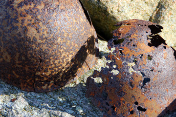 Punched rusty helmets on the stones