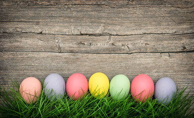 Easter eggs in green grass wooden background vintage