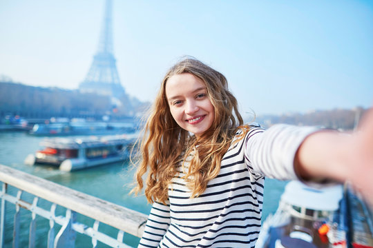Beautiful young girl taking funny selfie in Paris