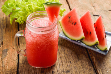 Healthy watermelon smoothie on a wood background and slices of w