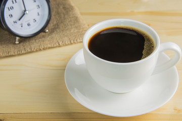 Black coffee in cup of coffee on wooden background