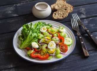 Fresh salad with cherry tomatoes, cucumbers, sweet peppers, celery and quail eggs. Healthy tasty food