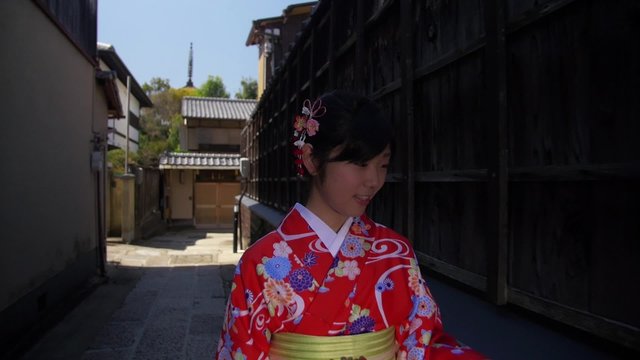 Beautiful young Japanese Girl wearing Kimono explores Kyoto streets