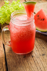 Healthy watermelon smoothie on a wood background and slices of w