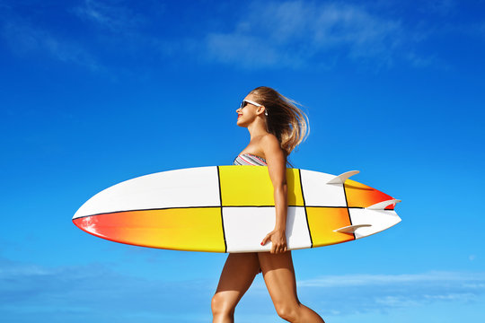 Healthy Active Lifestyle. Surfing. Water Sports. Beautiful Athletic Surfer Woman With Sexy Fit Body In Bikini With Surf Board Walking On Sea Beach. Summer Vacation. Extreme Sport. Summertime Fun Hobby