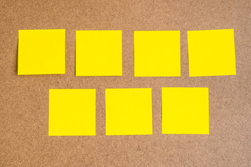 Seven black yellow sticky notes on brown wood board