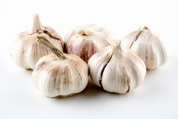 Purplish garlic heads with crackling skin isolated on white