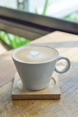 Hot latte coffee in glass  cup mug on wooden table