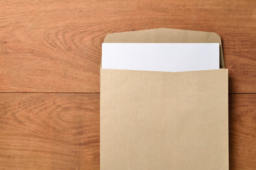 Blank paper and envelope on wooden background