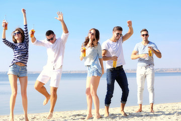 Obraz premium Young people with beer on the riverside