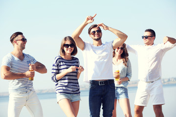 Obraz premium Young people with beer on the riverside