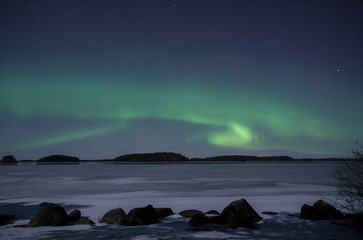 Moonlight lake landscape with northern lights in winter