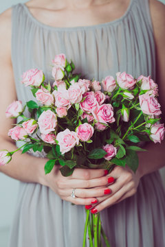 Close up image of bridesmaid with a bouquet of rose flowers